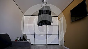 Men's suit on a hanger hanging on the wooden stairs of a two-story house