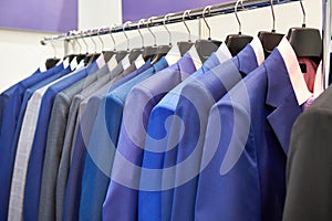 Men`s suits with shirts in clothing store