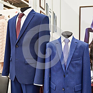 Men`s suits with shirts and ties in clothing store