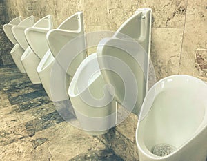 Men`s toilet. white faience urinals are fixed on the wall. going to the toilet while standing. relief of need. plumbing inventory