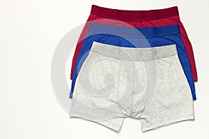 Men`s underwear, set of multi-colored underpants on white background flat lay top view copy space. Fashion blog, natural underwea