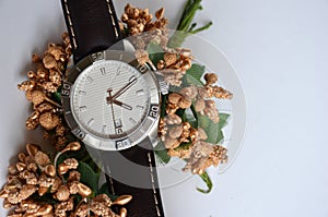 Men's watch on a white background with flowers.
