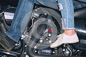 Men's and women's feet on motorcycle footboard