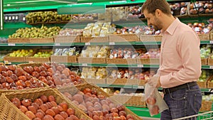 Men selecting fresh red apples in grocery store