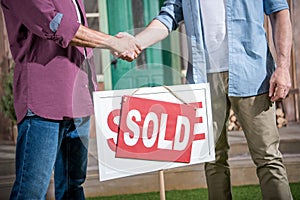 Men shaking hands with saleman and buying new house photo