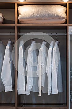 Men shirt white color hang on wardrobe or the wooden closet interior decoration of modern home architecture
