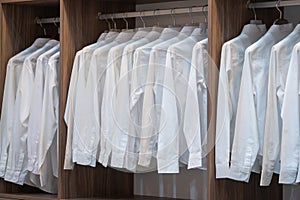 Men shirt white color hang on wardrobe or the wooden closet interior decoration of modern home architecture