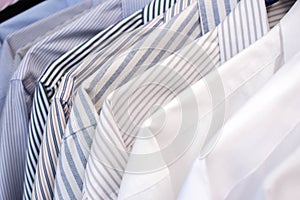 Men shirts hanging on rack in a row, Selective Focus