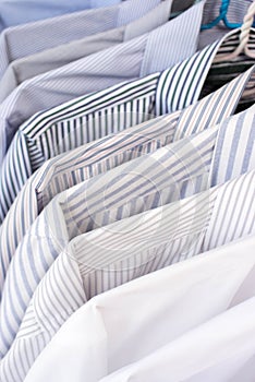 Men shirts hanging on rack in a row, Selective Focus