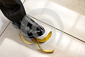Men shoe stepping on banana peel
