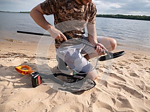 Men on the shore getting ready for a treasure hunt with a metal detector