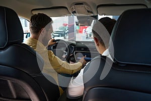 Men sit in the interior of a modern car