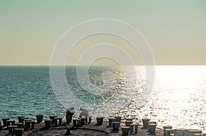 Men sitting on the benches on the seaside looking at their phones