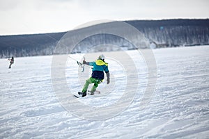 Men ski kiting on a frozen lake