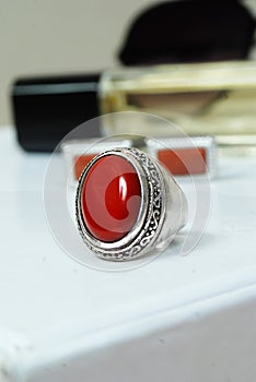 men spiritual stone ring  on white macro focus blurry background red coral gemstone closeup