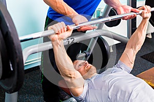 Men in sport gym training with barbell
