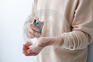 Men are spraying perfume on his wrist