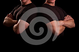 Men with strong hands. Male guards in a black T-shirt. Two men shoulder to shoulder