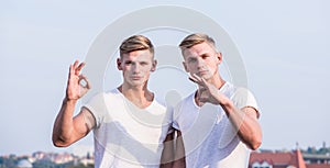 Men strong muscular athlete bodybuilder posing confidently in white shirts. Masculinity concept. Attractive twins. Sport