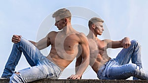 Men strong muscular athlete bodybuilder relaxing. Attractive twins. torso attractive body. Denim pants emphasize