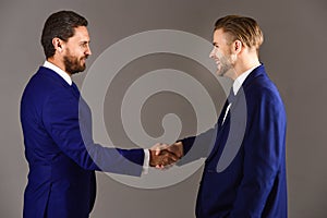 Men in suits or businessmen hold hands each other