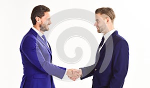 Men in suits or businessmen hold hands in handshake.