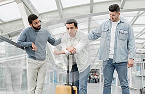 Men Supporting Unhappy Friend Having Problem During Trip At Airport