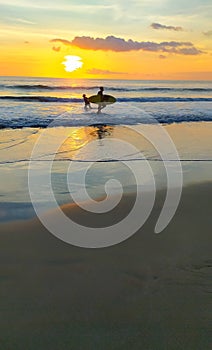 Men with surfboard with sunset view at Kuta beach Bali Indonesia