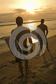Men With Surfboard Watching Sunset At Beach