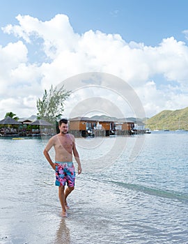 men in swim short on the beach of the tropical Island Saint Lucia or St Lucia Caribbean.