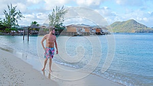men in swim short on the beach of the tropical Island Saint Lucia or St Lucia Caribbean.