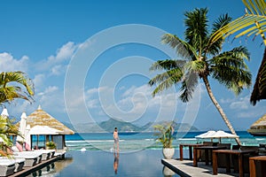 men at a swimming pool at a luxury hotel with a view over the ocean