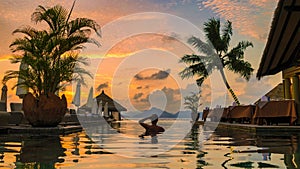 men at a swimming pool at a luxury hotel with a view over the ocean,Luxury pool tropical resort