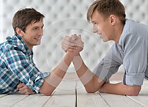 Men at the table and armwrestling