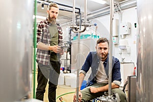 Men with tablet pc at craft beer brewery kettle