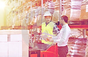 Men with tablet pc and forklift at warehouse