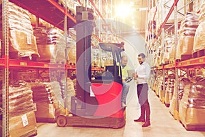 Men with tablet pc and forklift at warehouse