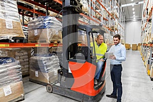 Men with tablet pc and forklift at warehouse