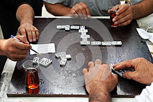 Men in teahouses drink tea and play dominoes photo