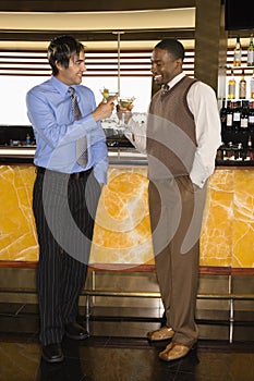 Men toasting at martini bar photo