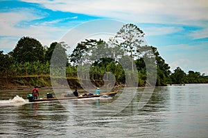 Men travel by canoe in the middle of the river Atrato