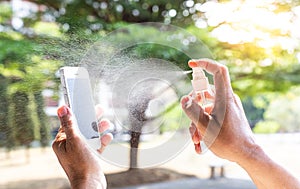 Men use alcohol spray to get rid of bacteria and viruses on mobile phones