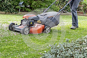 Men use lawnmowers in the front yard.