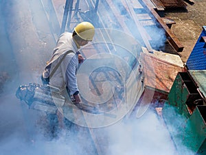 Men are using fogging machine to get rid of mosquitoes and insects