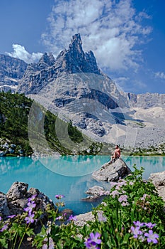 men visiting Lago di Sorapis in the Italian Dolomites,blue lake, Lake Sorapis Dolomites, Italy.