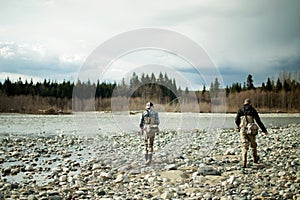 men walking by river anglers