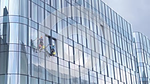 Men wash windows on a glass skyscraper in New York. Dangerous work at height