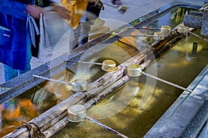 Men Washing Hands in Traditional Shinto Wash Basin At  Danjo Garan Sacred Temple in Koyasan