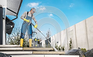 Men Washing His Backyard Garden Concrete Path and Stairs Using Pressure Washer