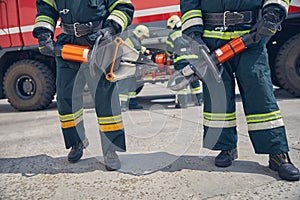 Men wearing protective uniform standing in front of fire modern machine